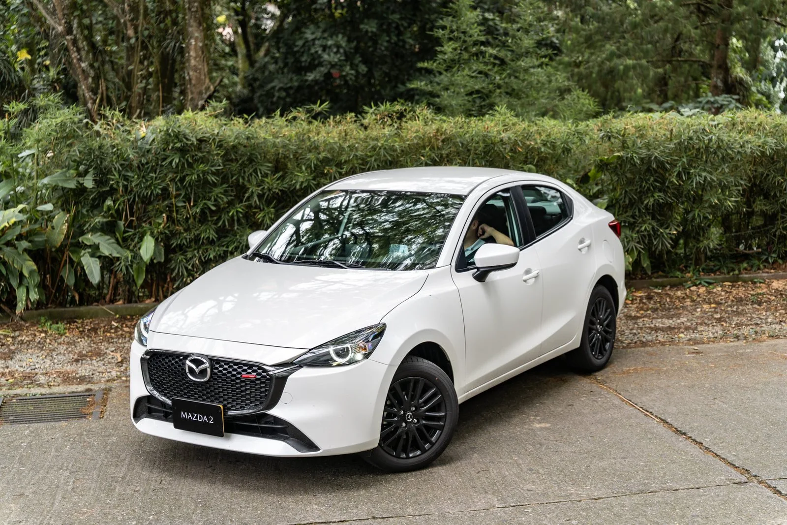 Mazda 2 Sedán vista lateral en jardín